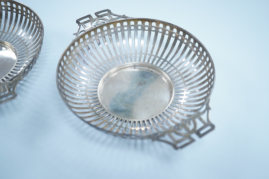 A pair of George V pierced silver two handled bonbon dishes, by Mappin & Webb, Birmingham, 1910, diameter 16.6cm over handles, possibly lacking glass inserts, 6.1oz.